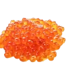 Salmon Caviar (Roe) displayed in a glass jar with a wooden spoon.