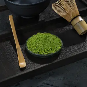 Bright green matcha powder pile from Hamasæen on dark background