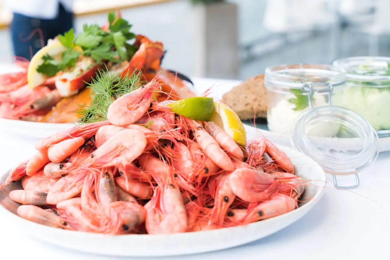 Plate of shrimp and seafood garnished with lemon and herbs, perfect for a gourmet meal.
